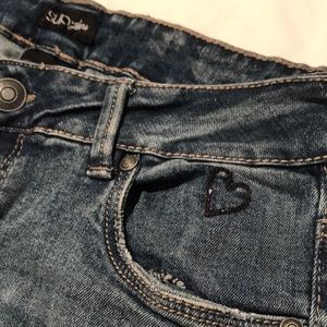Distressed blue jeans with one-of-a-kind details - size 4.